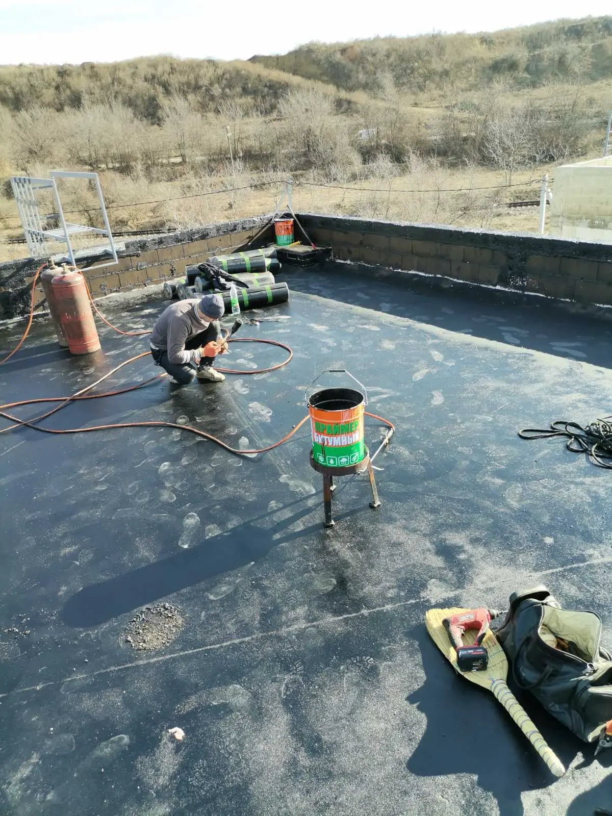 Echipă Acoperiș Nou aplicând membrană bituminoasă pe un acoperiș plat