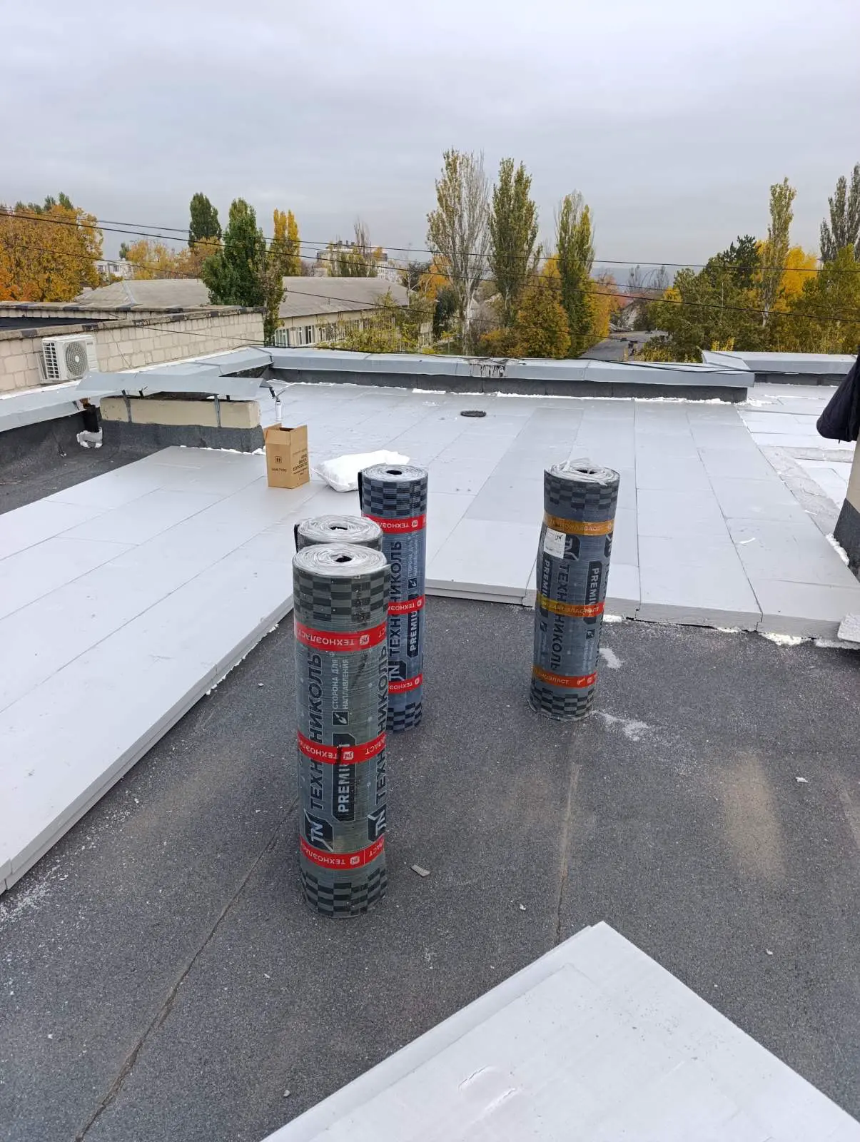 Roofer profesionist sudând membrană PVC pe acoperișul unei hale industriale